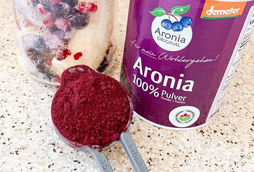 aronia powder on spoon with smoothie